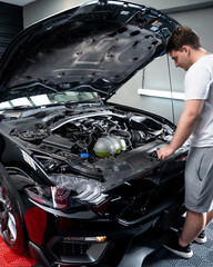 tecnico mecanico revisando motor con capot levantado