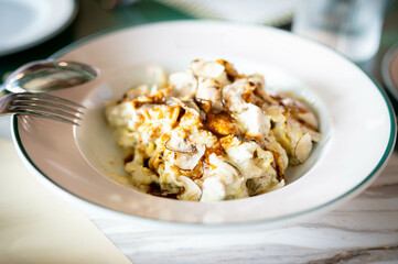 Pasta truffle with mushrooms in a white dish.