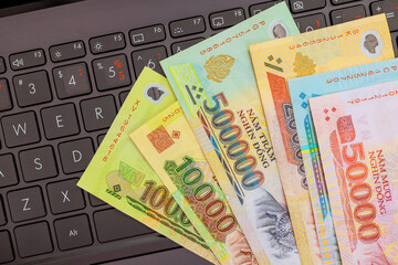Various nominal Vietnamese dong currency laid out on keyboard indicates currency exchange activity in market setting.