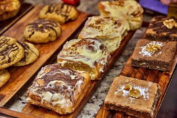 Freshly baked pastries and cookies in Ecuadorian bakery-cafe displayed on wooden boards, showcasing...