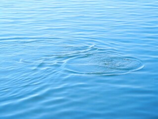 Calm blue water surface with gentle ripples and circular patterns creating a peaceful and soothing atmosphere