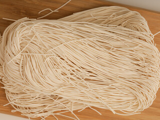 Vermicelli on wooden tray on white background
