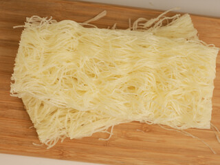 Vermicelli on wooden tray on white background