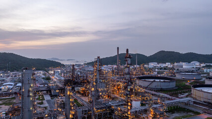 Naklejka premium Oil and gas industrial refinery at night, Oil and gas refinery petrochemical plant pipeline steel, Oil and gas refinery factory oil and gas storage tank pipeline steel at night, Global energy refinery