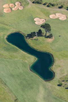 Aerial view over a lake and bunkers on a golf course