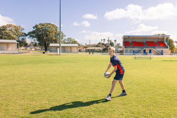 Junior rugby union player practicing ball passes on field