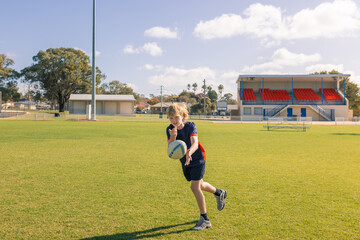 Junior rugby union player practicing ball passes on field