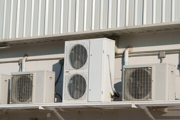 Air compressor or air condenser unit located on support outside building to heat released transferred to surrounding environment, Compressor is part of cooling function and air conditioning HVAC syste