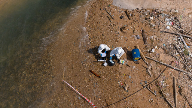 A male and female biologist are analyzing water test results and collecting samples for examination