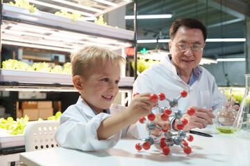Kids and families have fun holding molecular models to learn about chemistry in the classroom,...