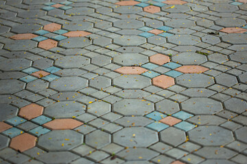 Close up shot of paving stone concrete block in octagon, hexagon and square shape, in vintage grey and brown color , also with tiny fallen leaves on their surface