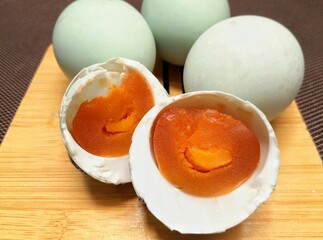 Salted eggs served on a wooden tray. Processed food made from duck eggs.