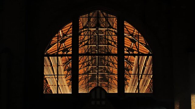Interior lights and ventilation fans glow inside Āgenskalns market on dark night