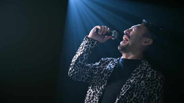 ライブハウスで上を向いて歌うアジア人（日本人）男性の縦動画　シャウトするロック歌手のようなイメージ