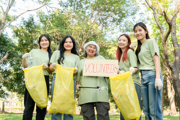 Volunteers participating in park cleanup activity, Group of cheerful volunteer women picks up trash...