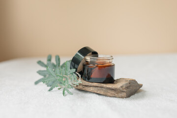 Small amber glass lotion tub in minimalist setting