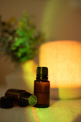 Essential oil diffuser in minimalist space with amber bottles and light causing rainbow effect
