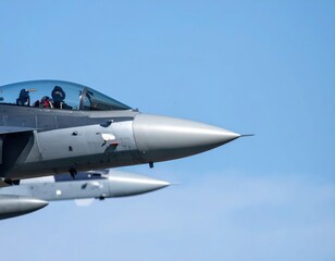 Obraz premium Close-Up View of Jet Nose and Wings in Mid-Flight Against a Soft Blue Sky Background