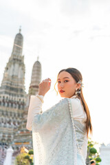 Fototapeta premium Young Woman in Traditional Thai Costume at Wat Arun, Temple of Dawn, Bangkok, Thailand