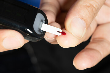 Woman's hands checking diabetes and hyperglycemia with digital blood sugar meter. Healthcare and...
