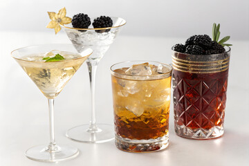 Three elegant cocktails with blackberries and ice