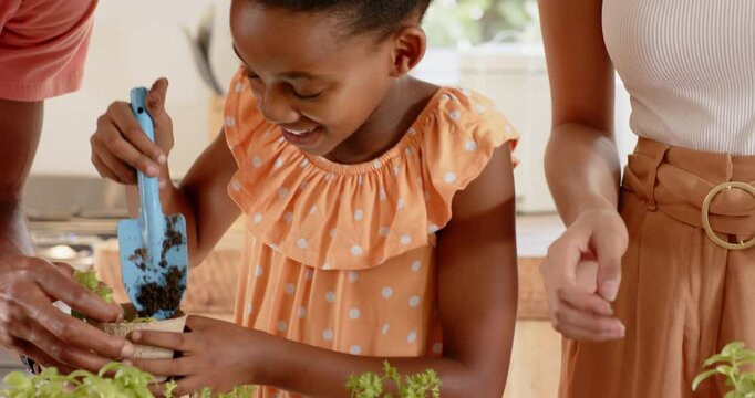 African american father and daughter joyfully exploring herbs together in kitchen at home