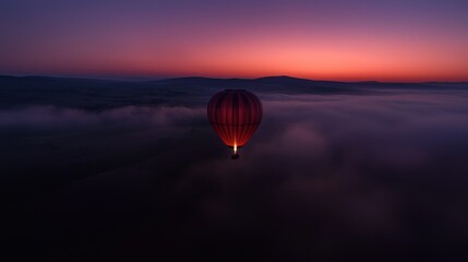 Obraz premium A lone hot air balloon floats above the morning fog and sky