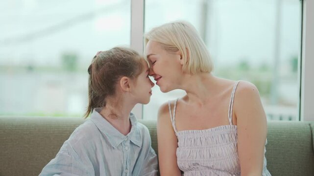 Portrait of mother and daughter touching foreheads with closed eyes and warm smiles, expressing affection and deep emotional bond in intimate family moment, scene is filled with love and connection.