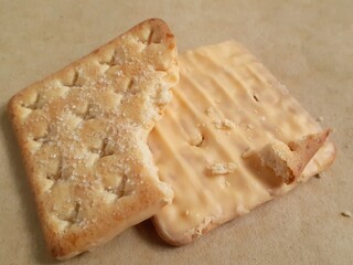 The remaining bitten crackers or biscuits are placed on a wooden board.
