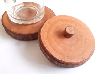 Rustic round glass lid and coaster made of tree trunk isolated on white background.