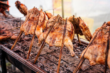Kai Yang Wichian Buri Whole grilled chicken marinated in traditional spices on the charcoal stove on stalls are located on the roadside is very Popular Street food of Thailand.