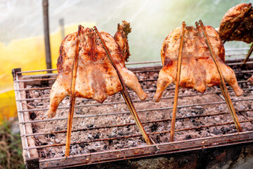 Kai Yang Wichian Buri Whole grilled chicken marinated in traditional spices on the charcoal stove on stalls are located on the roadside is very Popular Street food of Thailand.