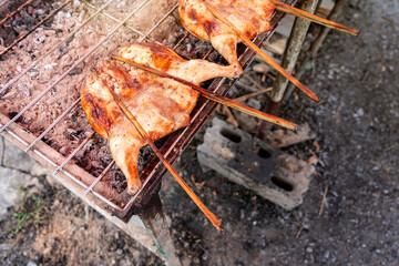 Kai Yang Wichian Buri Whole grilled chicken marinated in traditional spices on the charcoal stove on stalls are located on the roadside is very Popular Street food of Thailand.
