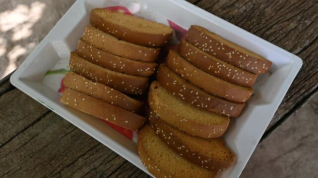 Crispy rusk, Biscuits cake rusk over wooden background , a crunchy snack infused with traditional spices, perfect for tea or coffee. A delightful treat for your mornings or tea time