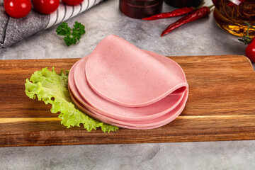 Sliced boiled sausage over board