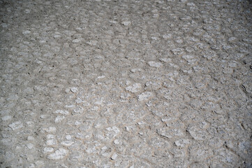 Close-up view of textured concrete surface revealing irregular patterns and gray tones in an urban environment during daylight hours