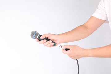 Hand holding microphone on white background.