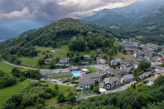 Drone panorama of the Ivrea Morainic Amphitheatre seen from Brosso, Val Chiusella, Italy, showing lush green plains, woods, and scattered villages under clear sky, high drone shot, slow motion