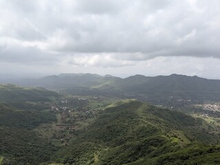 Cloudy mountain valley with scattered villages in monsoon