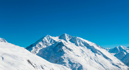 Majestic Snowcapped Mountain Peaks under a Vivid Blue Sky Winter Wonderland Landscape Breathtaking Alpine Scenery Serene Nature Photography