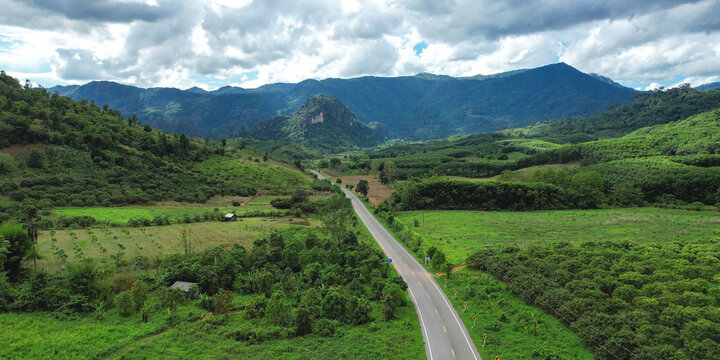 Aerial view of the road among the forest and mountains - Powered by Adobe