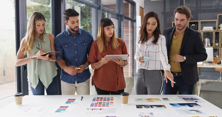 Group, creative business people and discussion in meeting for brand strategist with tablet. Team, manager and collaboration in startup office for planning, proposal and choice for ad campaign design