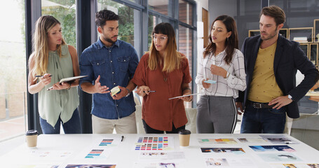 Team, creative business people and discussion in meeting for brand strategist with tablet. Group, manager or collaboration in startup office for planning, brainstorming or idea for ad campaign design