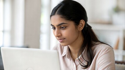 Indian girl attending virtual test on laptop	
