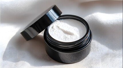 An open black jar of luxurious white skincare cream rests elegantly on a softly draped silk cloth, casting gentle shadows in the bright, diffused sunlight.