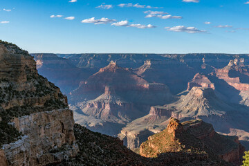 Panoramic views of the Grand Canyon, Arizona, USA, showcasing the dramatic landscape, layered rock formations, and vivid colors under a clear sky. Perfect for travel and nature themes.