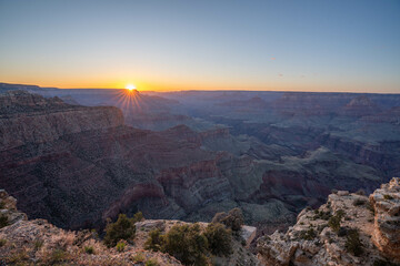 Stunning sunrise over the Grand Canyon, Arizona, highlighting the rugged canyon cliffs and deep valleys in breathtaking natural beauty. 