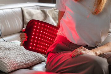 Infrared light therapy belt on the back reduces pain and inflammation from strain or injury. It...