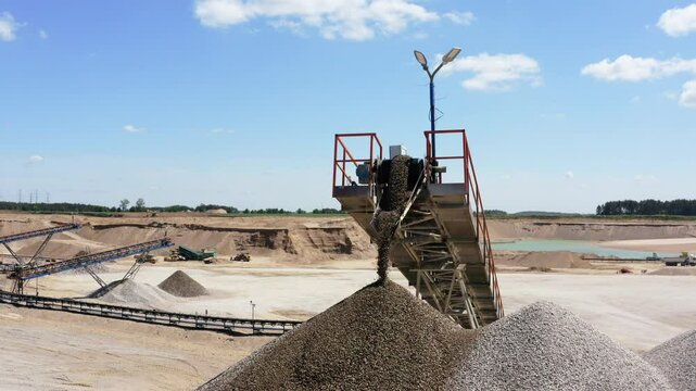 Conveyor Belt Offloading Gravel Into Large Pile At Quarry Site. closeup, drone shot