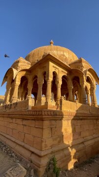 Bada Bagh in Jaisalmer is a peaceful place with beautiful old chhatris (cenotaphs) made of golden sandstone. On a sunny day, the clear blue sky Rajasthan India 4K
